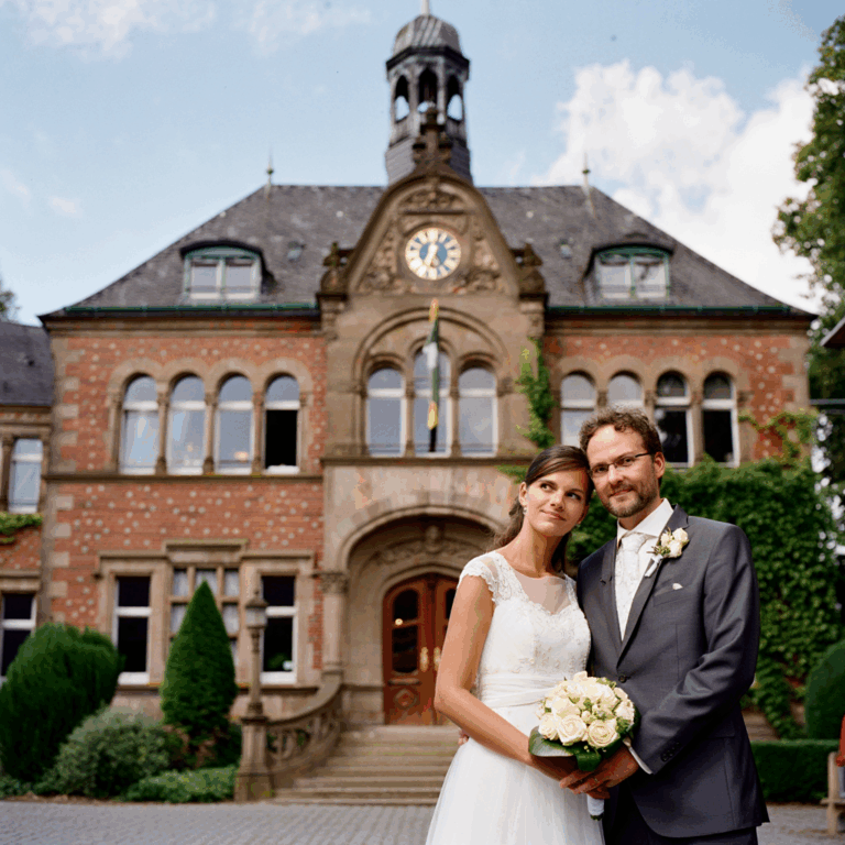 Glückliches Paar nach der Heirat vor einem deutschen Rathaus
