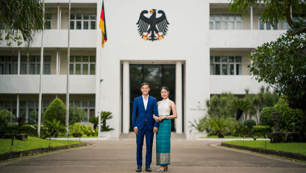 Glückliches Paar vor deutscher Botschaft – Einladung Laos nach Deutschland