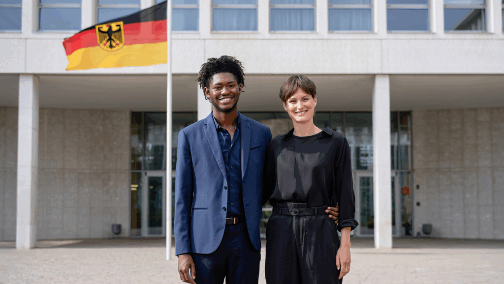 Glückliches Paar, ein lesothischer Partner mit seinem deutschen Partner vor einer deutschen Botschaft